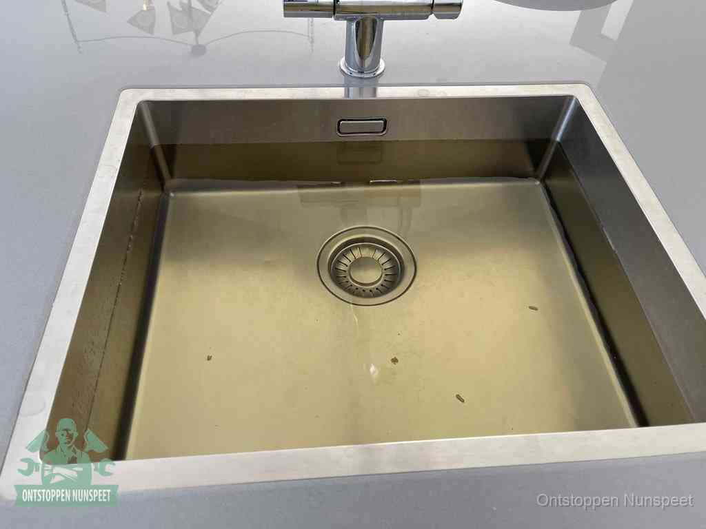 Een RVS spoelbak met stilstaand water dat niet wegloopt, een van de eerste signalen van een beginnende verstopping in Nunspeet