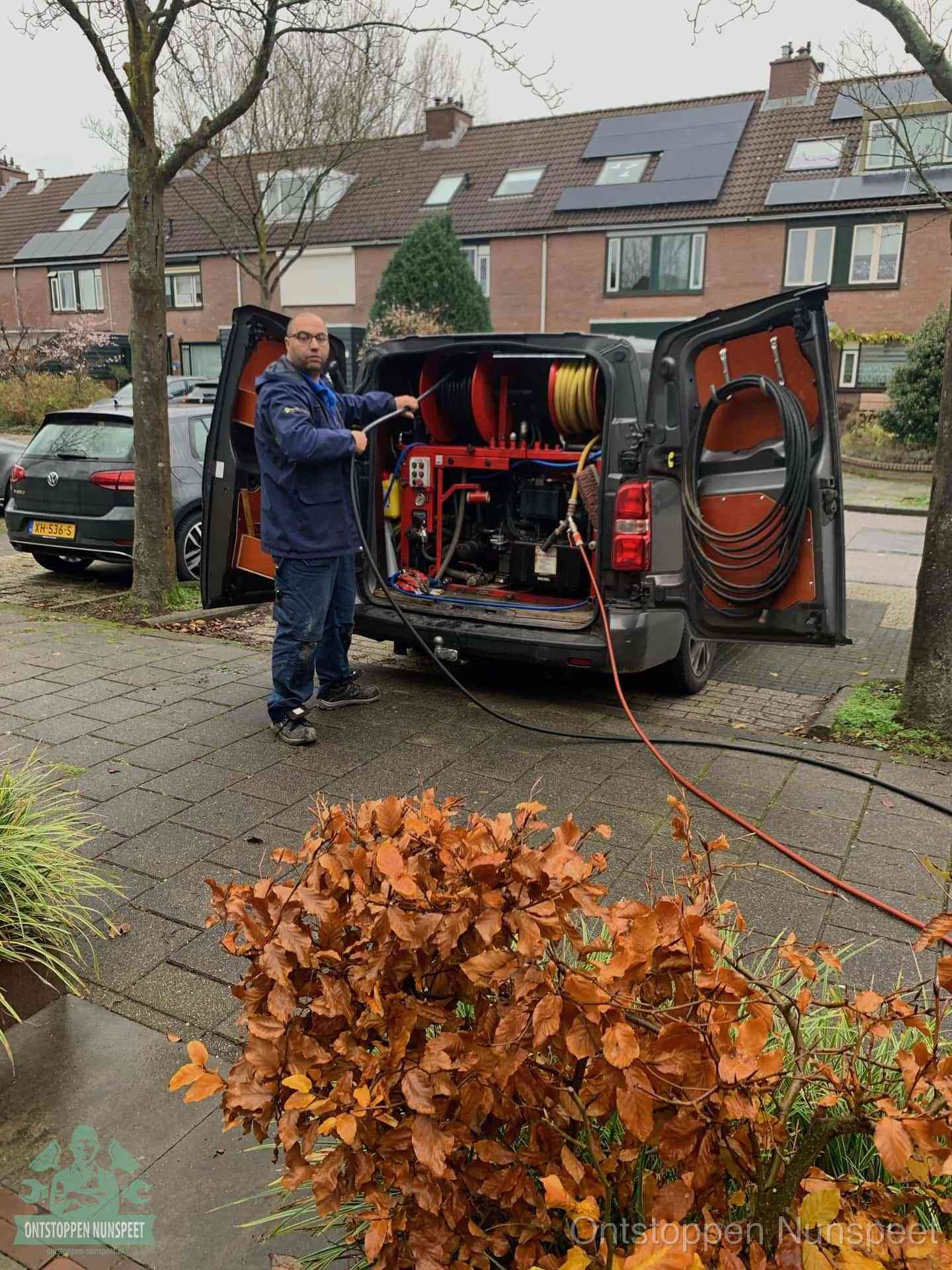 Een monteur staat bij zijn open bestelbus met hogedruk-rioolreinigingsapparatuur, klaar om binnen 30 minuten uit te rukken voor een spoedverstopping in Nunspeet