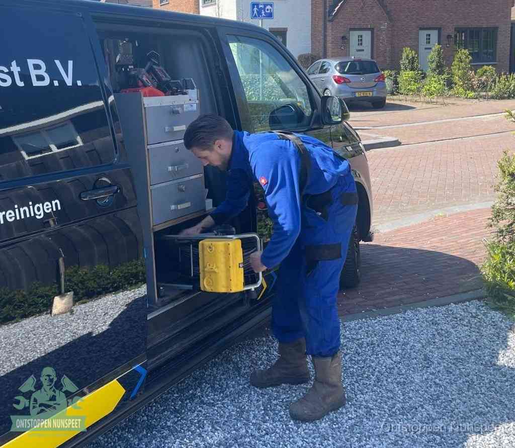 Een monteur pakt gereedschap uit de bedrijfsbus, het moment om een professionele ontstoppingsdienst in te schakelen in Nunspeet