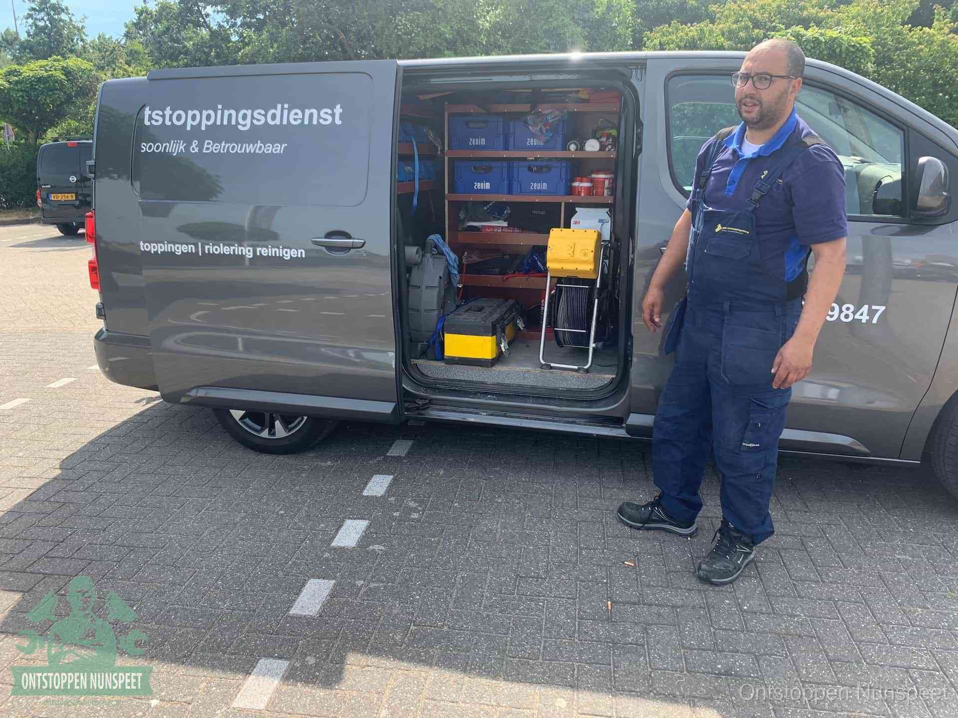 Een monteur staat klaar bij zijn bedrijfsbus met gereedschap, de vaste werkwijze van de ontstoppingsdienst in Nunspeet